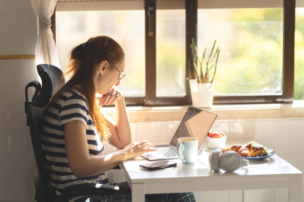 istock Adult woman freelancer working at the kitchen table 2170954163