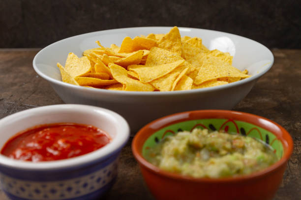 Table with guacamole, tomato and Mexican tortillas.