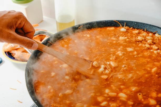 istock man cooking a spanish fideua in a paella pan 2170959112