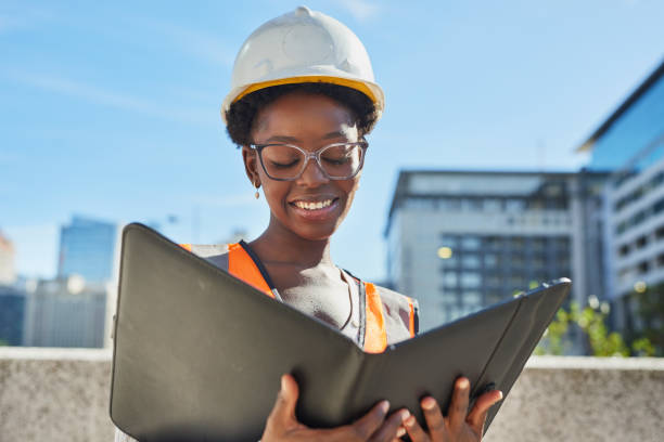 istock Smiling Female Engineer Reviewing Plans on Construction Site 2170966959