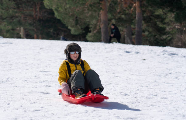 istock Happy boy sledding through the snow 2170967080