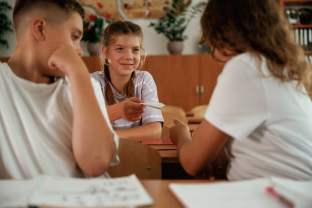 istock Taking the cheat sheet. Pupils, kids in the classroom together 2170969365