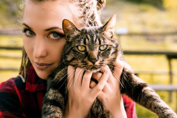 istock Young woman holding tabby cat outdoors in summer 2170969969