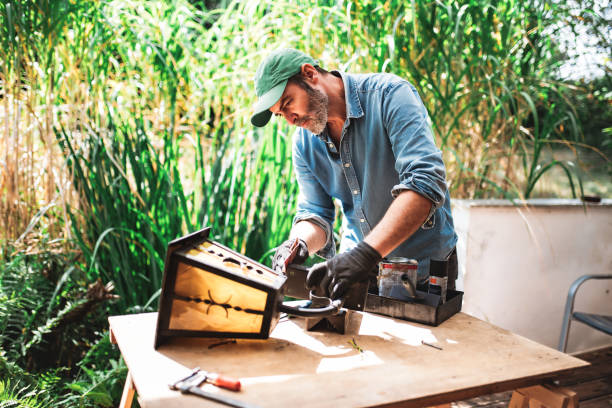 istock man repairing old lantern in garden 2170972315