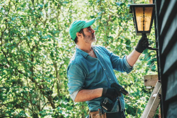 istock man mounting old lantern at wooden facade in garden 2170972375