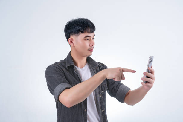 istock Handsome Asian man using smartphone on white background. Concept for advertising, finance business, communication, technology advancement and online shopping. 2170977184