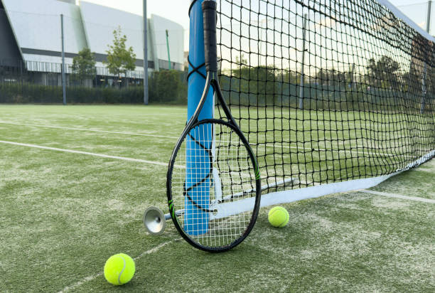 istock tennis racket with balls on green background. 2170977567