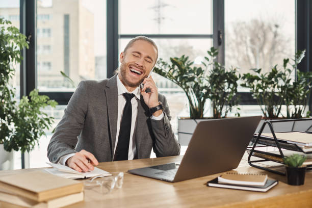 istock Handsome businessman smiling while on a call in a stylish modern office during the day 2170979244