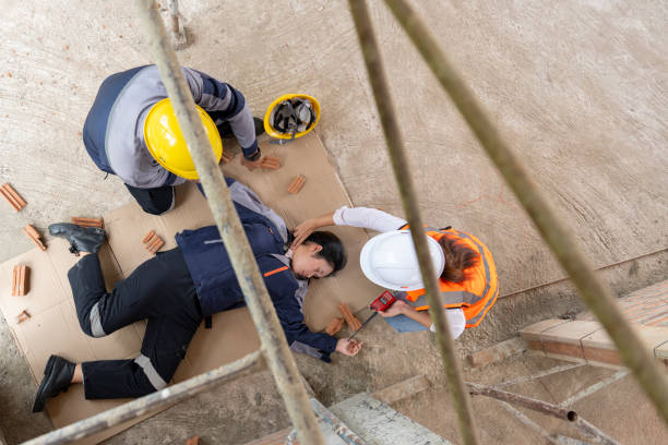 istock Work accident, Female construction worker falls from scaffolding, coworkers come to her aid and call for help 2170979430