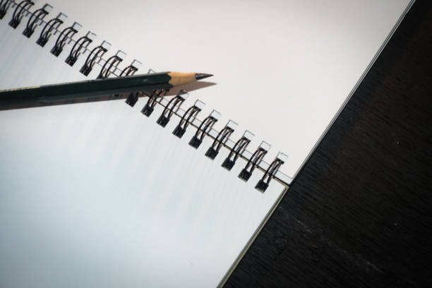 Closeup picture of a sketch book or notebook with a pencil isolated in black  background, design for National memo day