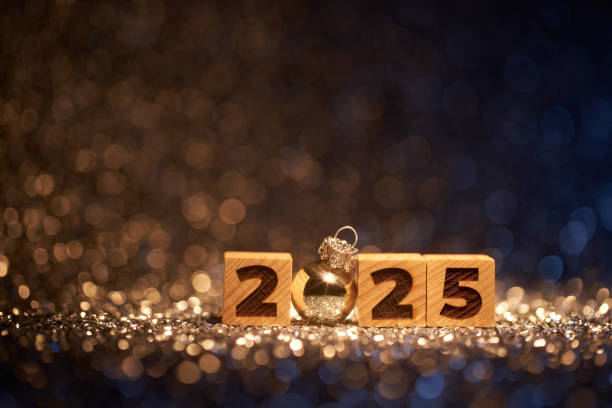 istock Wooden blocks displaying 2025 with a silver bauble, set against a sparkling backdrop of warm, defocused lights for a festive New Year's celebration. 2170987845