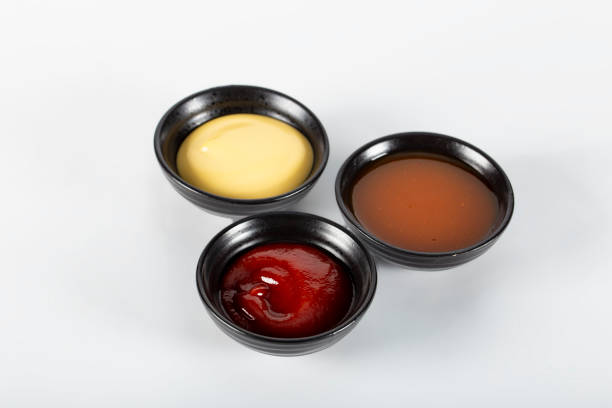 Three different sauces on a white background, ketchup, cheese sauce and chili sauce. High quality photo