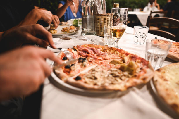 istock Friends eating pizza in a restaurant. 2170989222