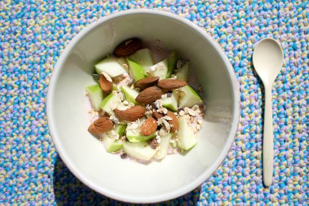 istock Muesli with raspberry yoghurt, oat flakes, chocolate, apple and almonds. Self-crocheted placemat in pastel colors. 2170989236