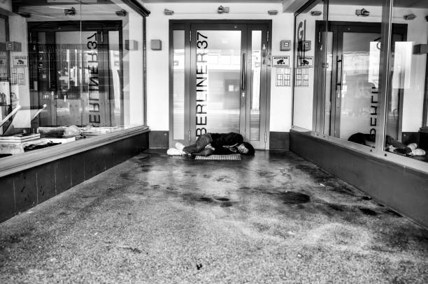 Frankfurt, Germany - July 29, 2024: A man sleeping in a corridor in Frankfurt in black and white