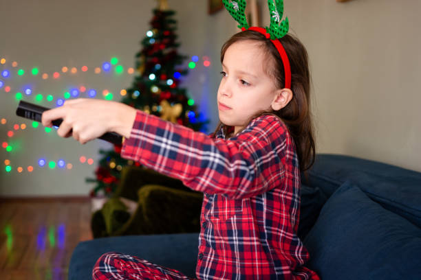 istock Girl changing channels on remote control during Christmas holidays 2170992692