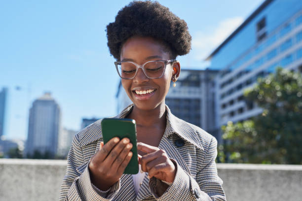 istock Smiling Woman Using Smartphone in Urban Setting 2170993608