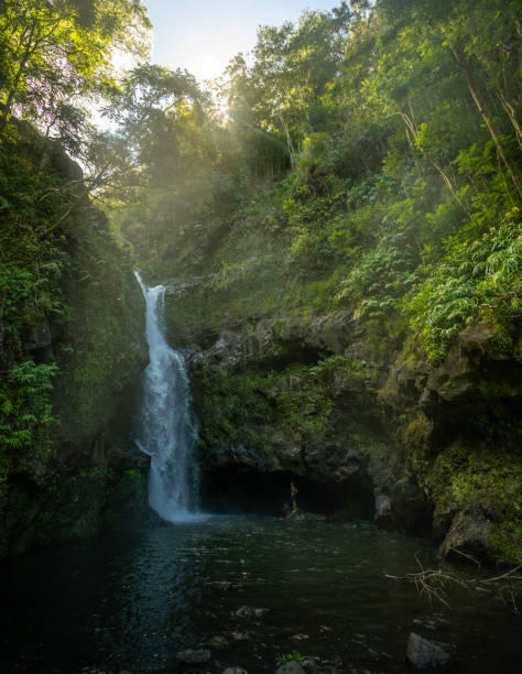 istock Young man standing at the bottom of a waterfall 2170997157