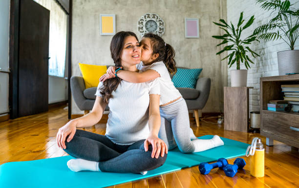 istock Daughter kissing her mother during exercise at home 2170997402