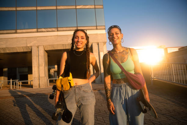 istock Two young woman walking with skateboard and smiling 2171000818
