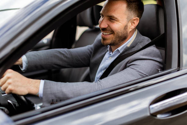 istock Smiling man enjoying a sunny drive in a modern car interior 2171001611
