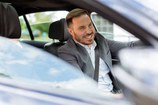 istock Smiling man enjoying a sunny drive in a modern car interior 2171001624