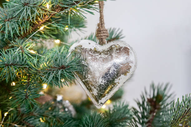 istock Metallic Christmas tree decorations in silver tones.Silver heart decor in shining garlands on a blue spruce.Metal Christmas decor. 2171002414