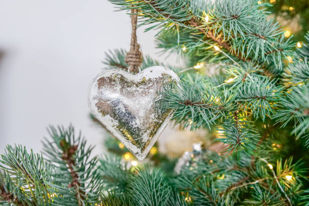 istock Metallic Christmas tree decorations in silver tones.Silver heart decor in shining garlands on a blue spruce.Metal Christmas decor. 2171002450