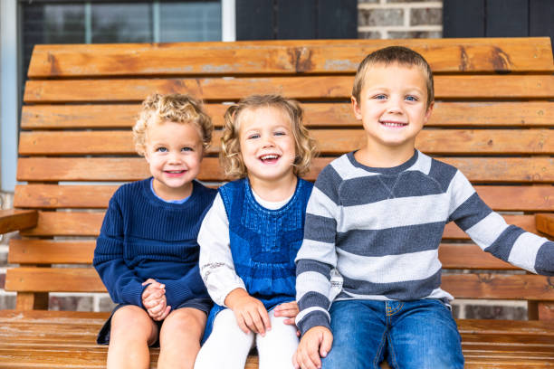 Siblings playing on porch swing