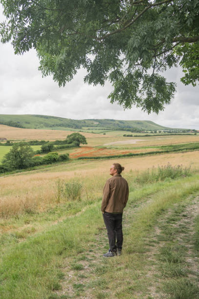 Young man explores rural landscape in summer