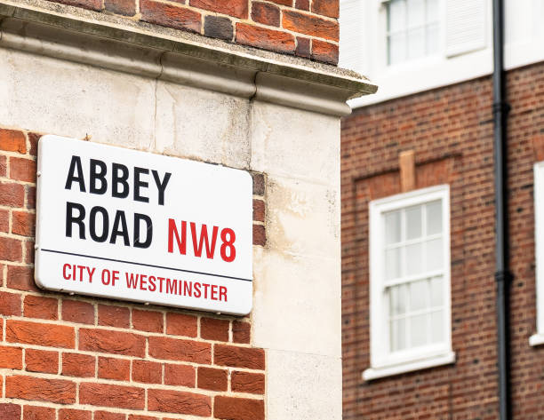 London, UK - A sign for Abbey Road the brick exterior of a building on the street.