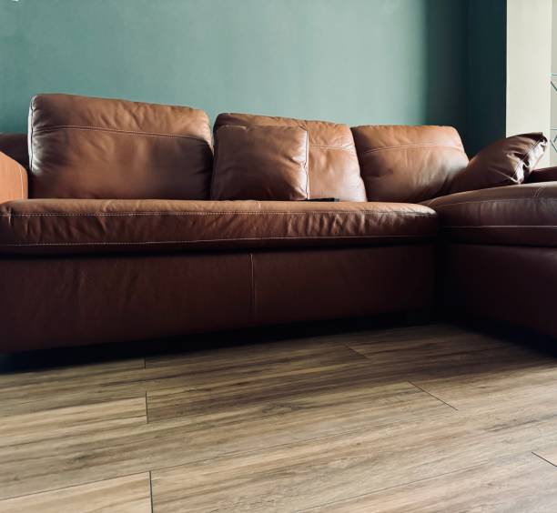 A brown leather sofa bed settee on wood floor in a domestic setting in our home