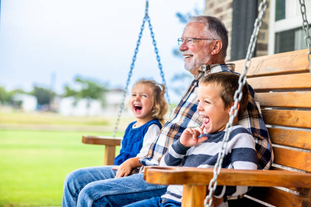 fun story time with grandpa on the porch swing - avô imagens e fotografias de stock