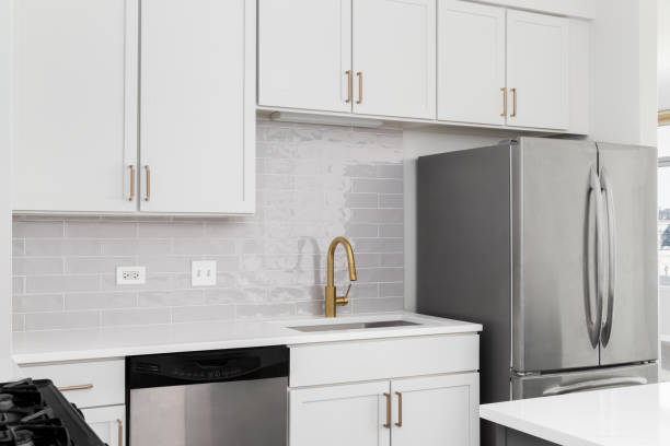 istock A kitchen detail with white cabinets, subway tile backsplash, and gold faucet and hardware. 2171007344