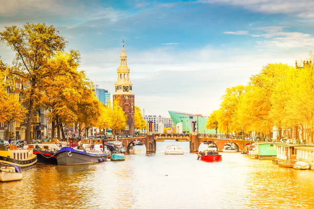 Amsterdam old town center with the Montelbaans tower and Amstel river, Netherlands at fall