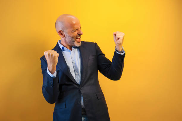 istock A man in a dark blue suit raises his arms in euphoria. 2171008301