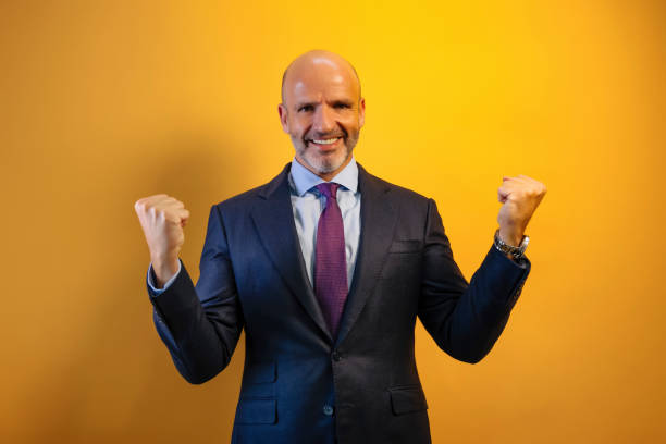 istock A man in a dark blue suit raises his arms in euphoria. 2171008409