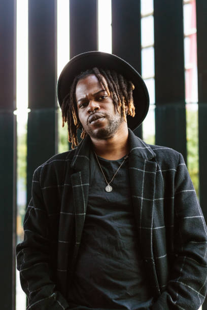 istock Stylish black man in hat standing on street 2171011989