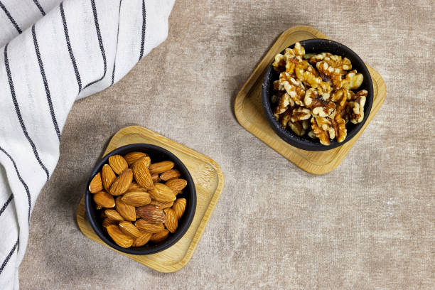 istock two black bowls of Almonds and Walnuts 2171012462