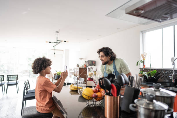 istock Boy filming father preparing smoothie at home 2171013237