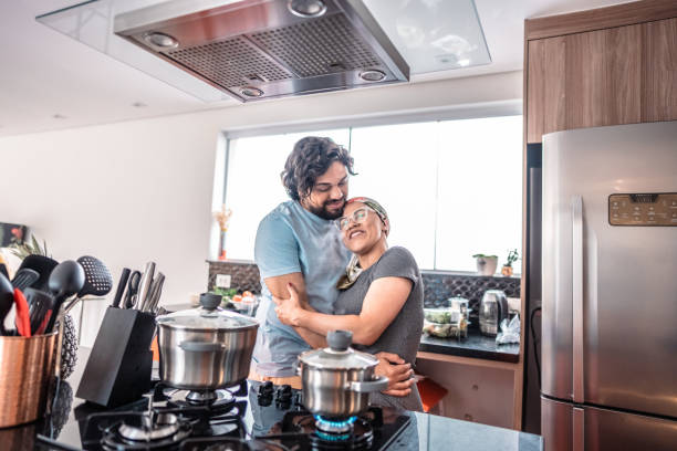 istock Couple embracing and cooking at home 2171015598