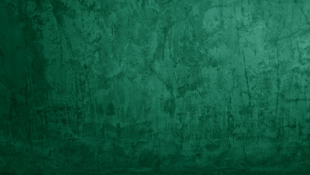 dark green grunge stucco concrete texture use as background with blank space for design. artistic green color cement wall background with light from above.
