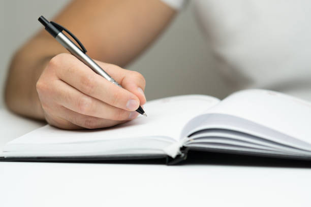 istock Young man hand writing in notebook close up 2171016399