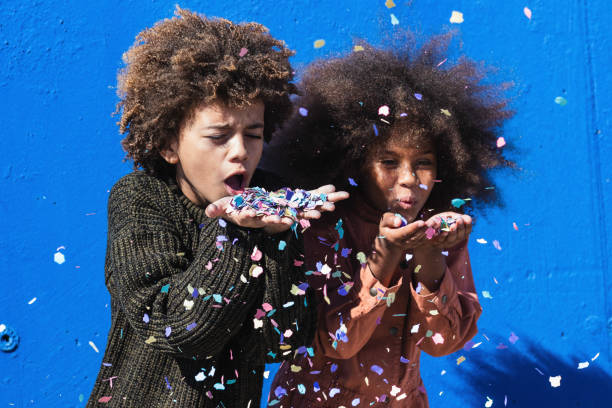 istock Cheerful black teenagers blowing confetti 2171020005