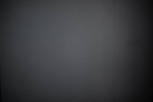 Close-up of a plain dark gray wall with a smooth, slightly textured surface. The minimalist and neutral background is perfect for use in design, presentations, or as a backdrop for creative projects