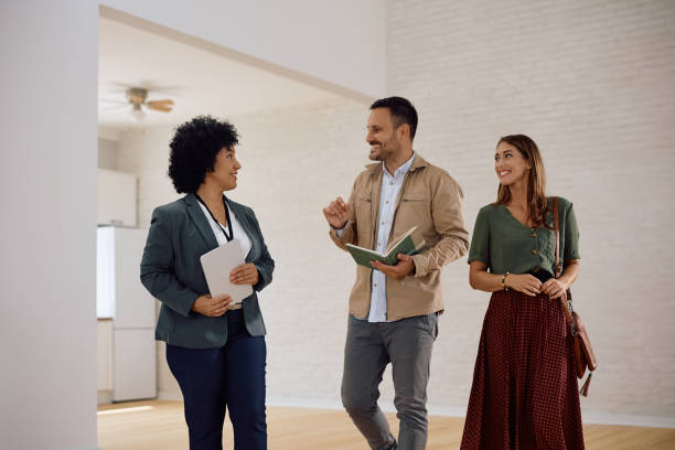 istock Happy couple communicating with their real estate agent while buying new house. 2171027310