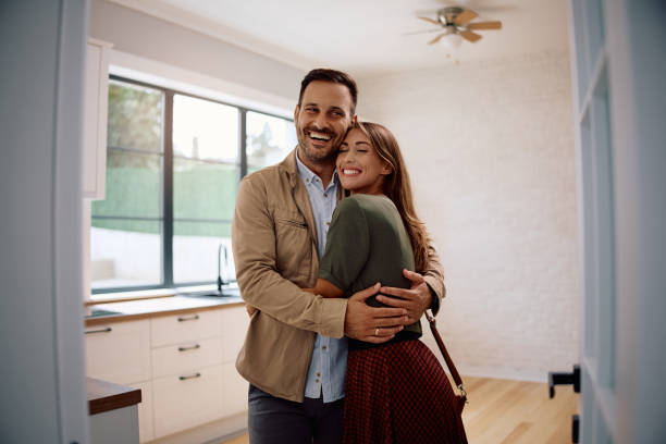 istock Happy couple standing embraced in their new home. 2171027388