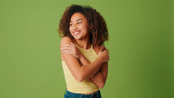 istock A girl hugging herself on a green screen background 2171029219