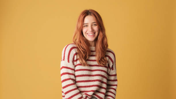 istock Smiling girl looking at camera on yellow background 2171029500