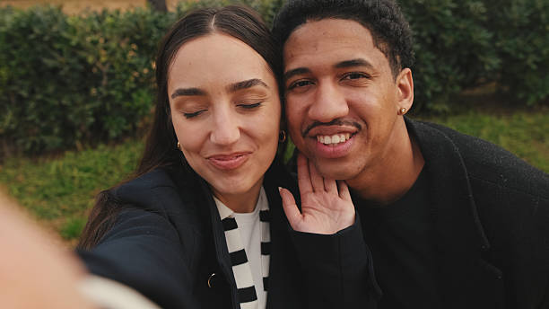 istock Multiracial couple taking selfie with smartphone in park 2171031088